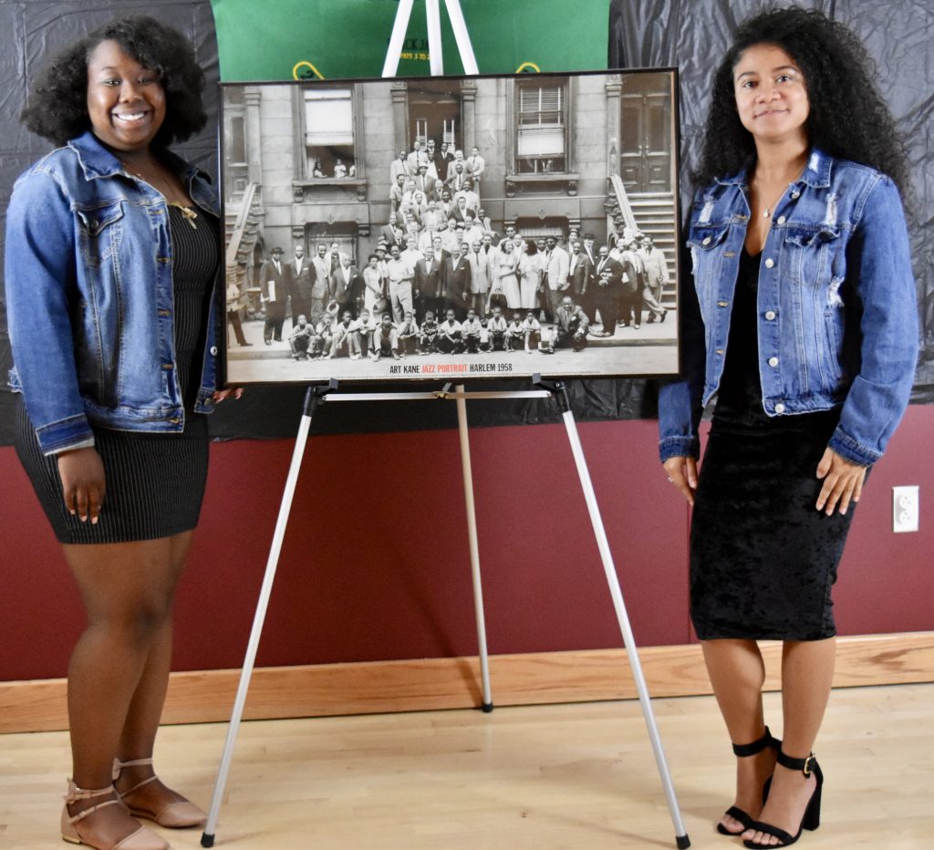 Attendees stand next to their photo/poster during the New Negro Movement Harlem renaissance event