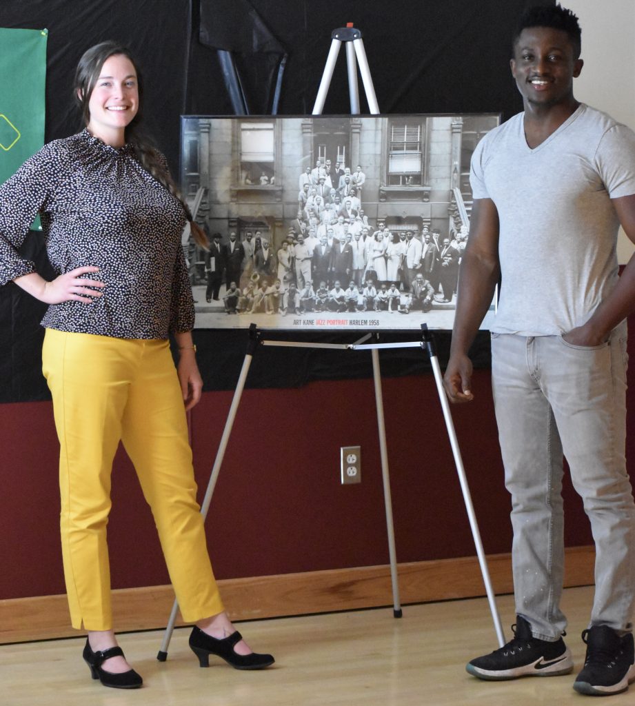 Participants stand next to their poster during the New Negro Movement Harlem Renaissance event