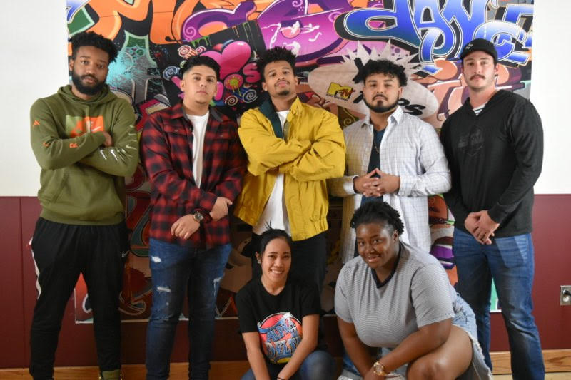Attendees at the hip-hop event during 2020 Black History Month standing in front of graffiti wall. 