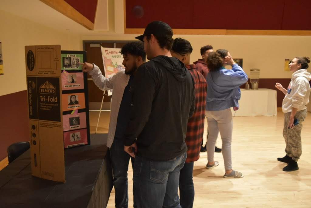 Attendees at the hip-hop event during 2020 Black History Month viewing posters on the evolution of hip hop. 
