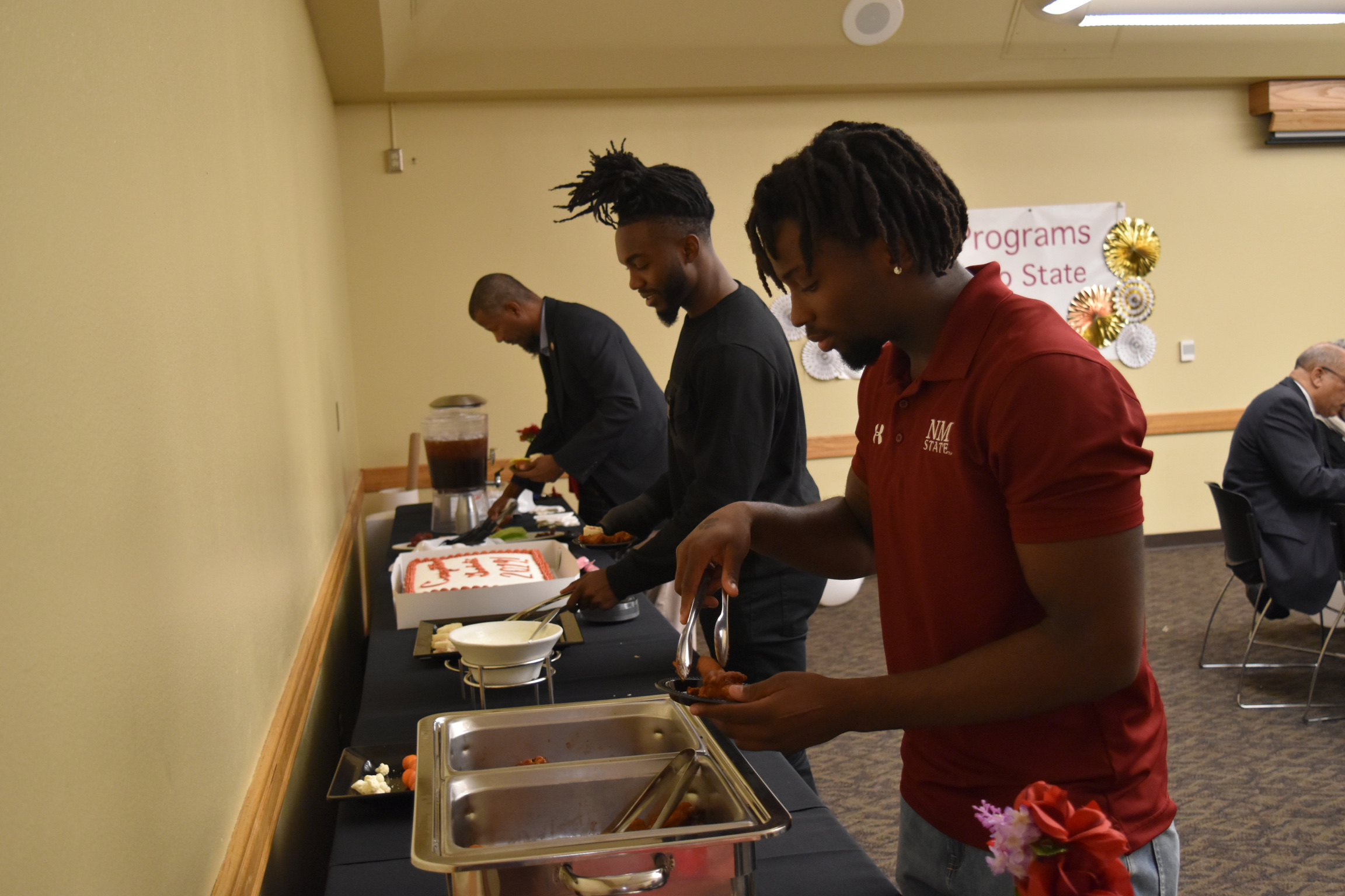 Attendees at the Fall 2019 Graduation Celebration get food from the buffet. 