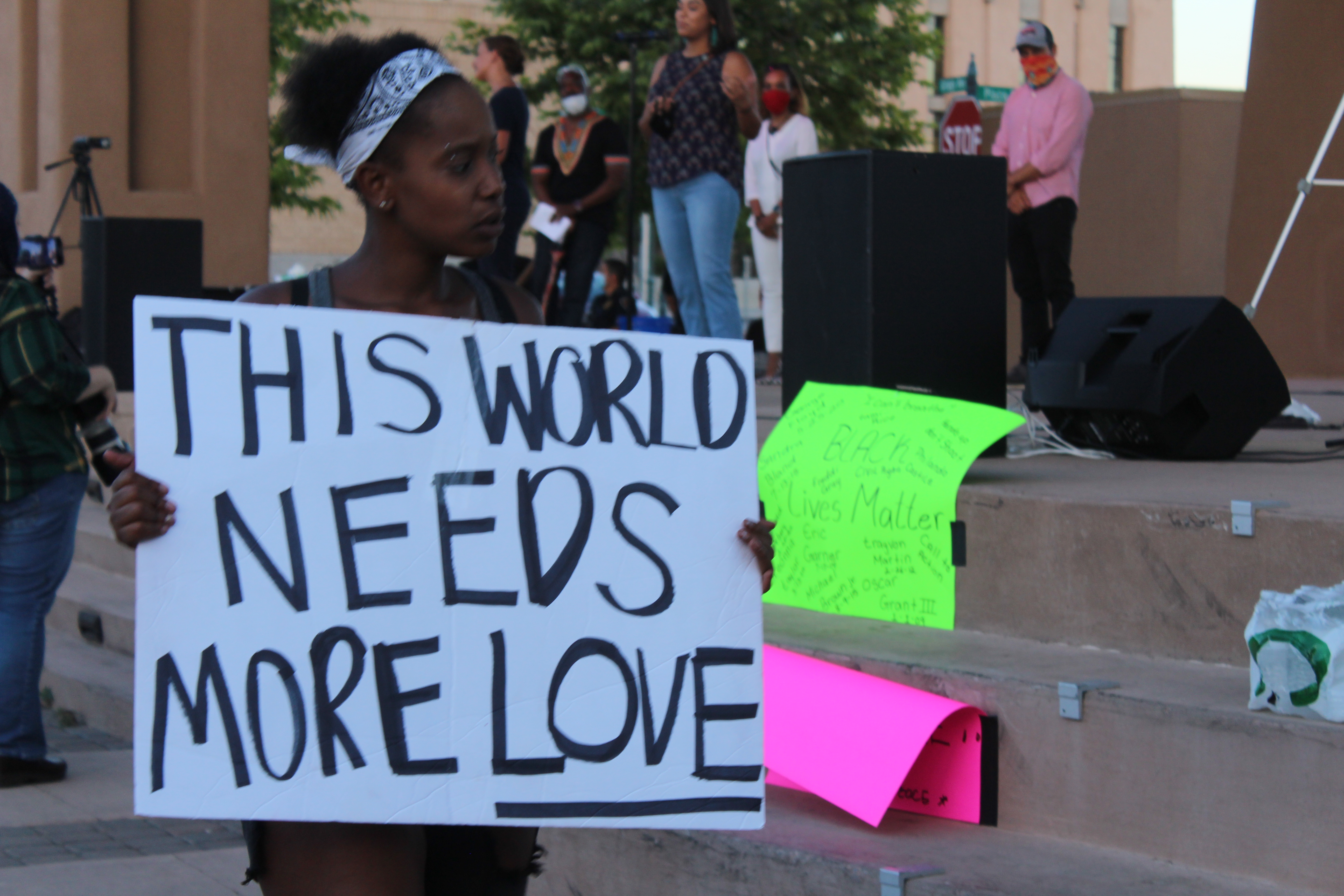 Attendee holds a sign that reads "the world needs more love"